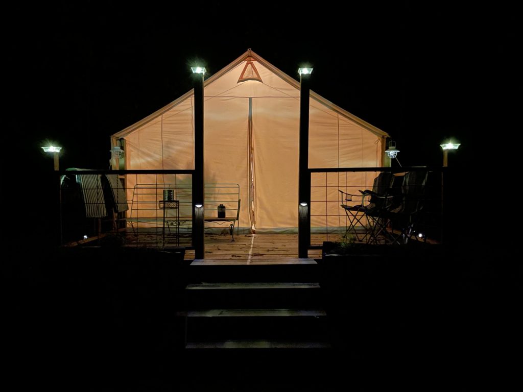 hilltop sunrise urban camping wall-side tent at night new river gorge bridge summit Bechtel reserve boy scout camp Fayette county Fayetteville oak hill hilltop WV West Virginia tent deck with planters, ferns and picnic table