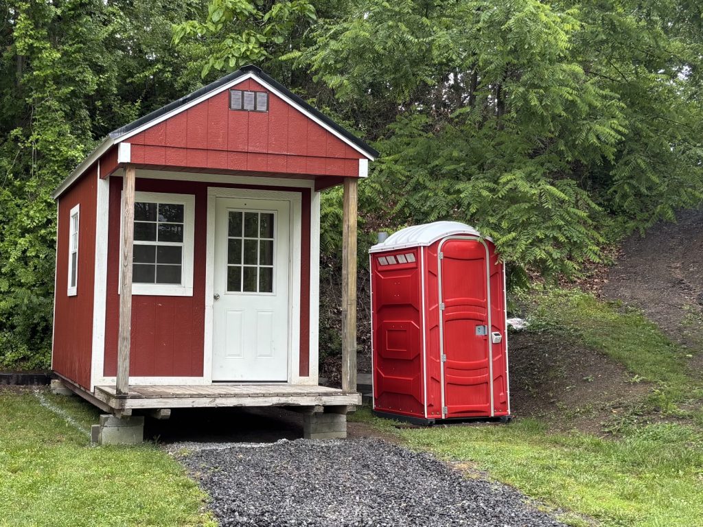 hilltop sunrise urban camping bunkie-style cabin with private hot outdoor shower sink flush toilet new river gorge bridge national park and preserve Fayette county Fayetteville oak hill hilltop WV West Virginia June 2026